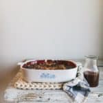 crumble in dish and syrup in jar on top of table