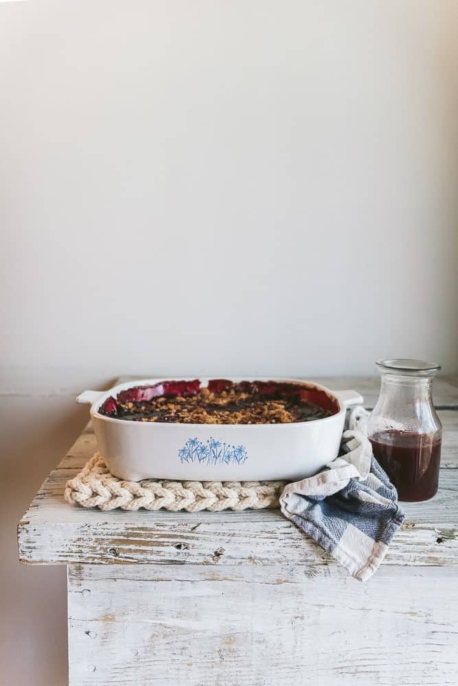 crumble in dish and syrup in jar on top of table