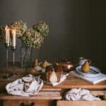 table with candles, dried hydrangeas, ginger pear loaf and copper pot