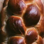 flatlay of braided challah bread on a cutting board