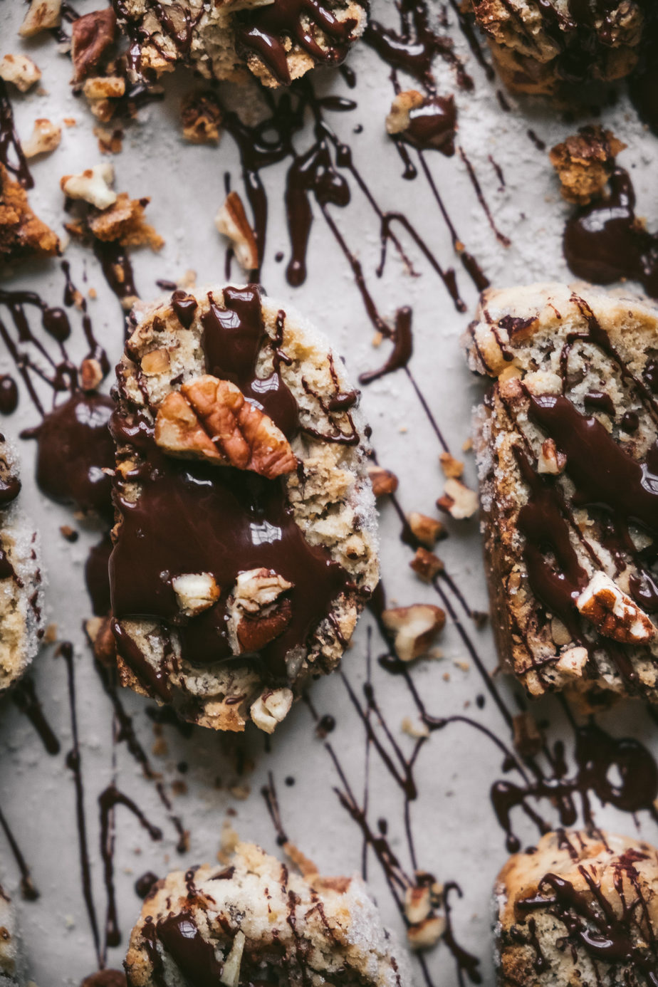 flatlay of biscotti cookies with chocolate drizzle and pecans