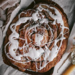 flatlay of giant cinnamon roll with cream cheese icing