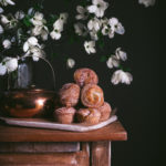 cinnamon sugar cruffins on a table next to dogwood flowers