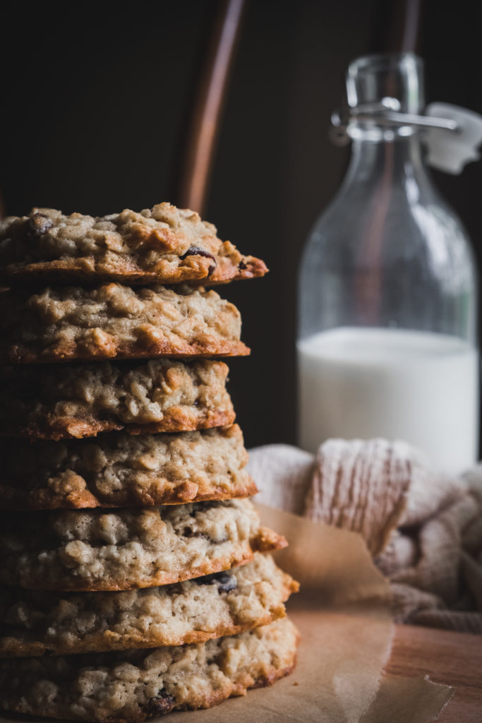 stack of cookies next to jar of milk