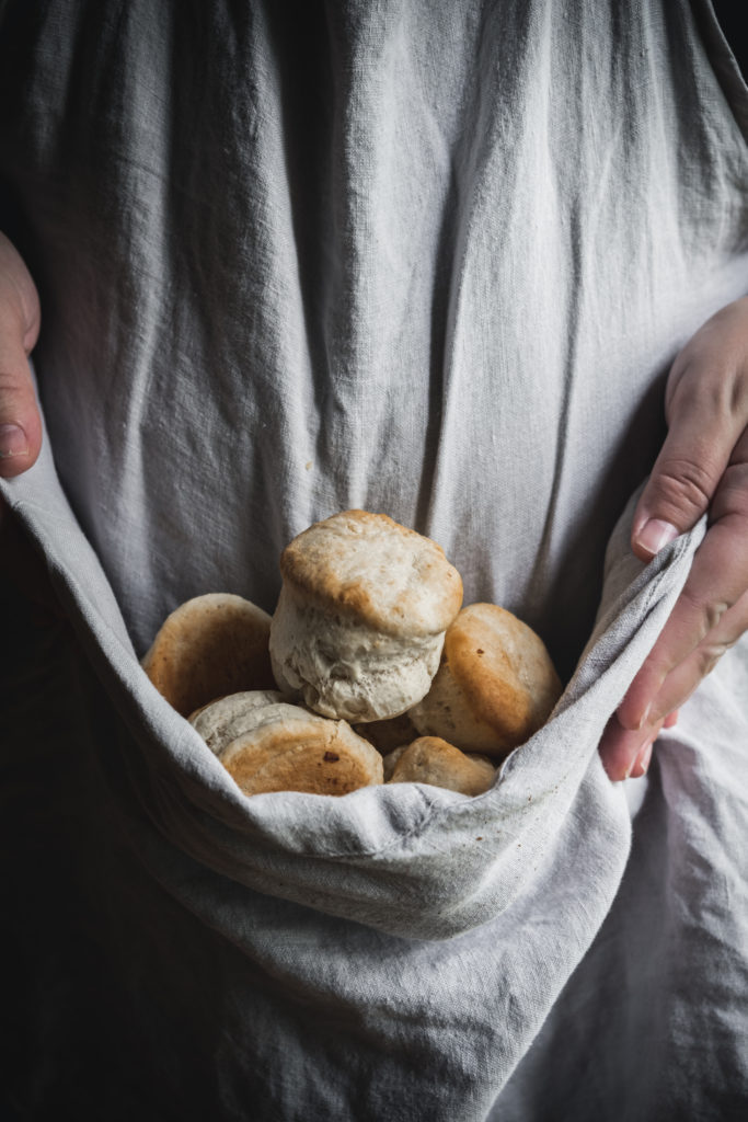 woman holding apron full of biscuits