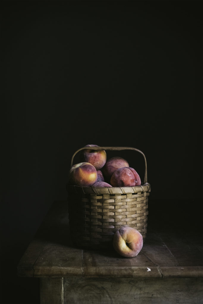 basket of peaches on a table